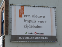 826010 Afbeelding van een reclamedoek voor het bouwproject 'Zijdebalen Wonen' aan de zijgevel van het voormalige ...